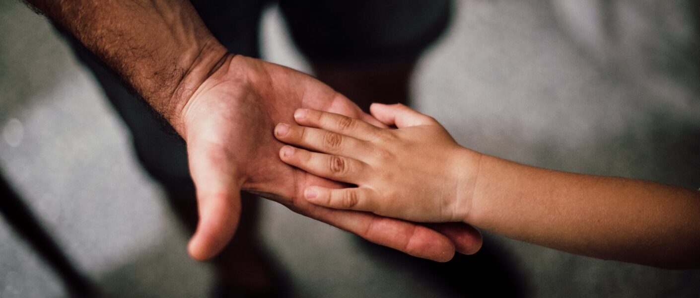 selective focus photography of child s hand